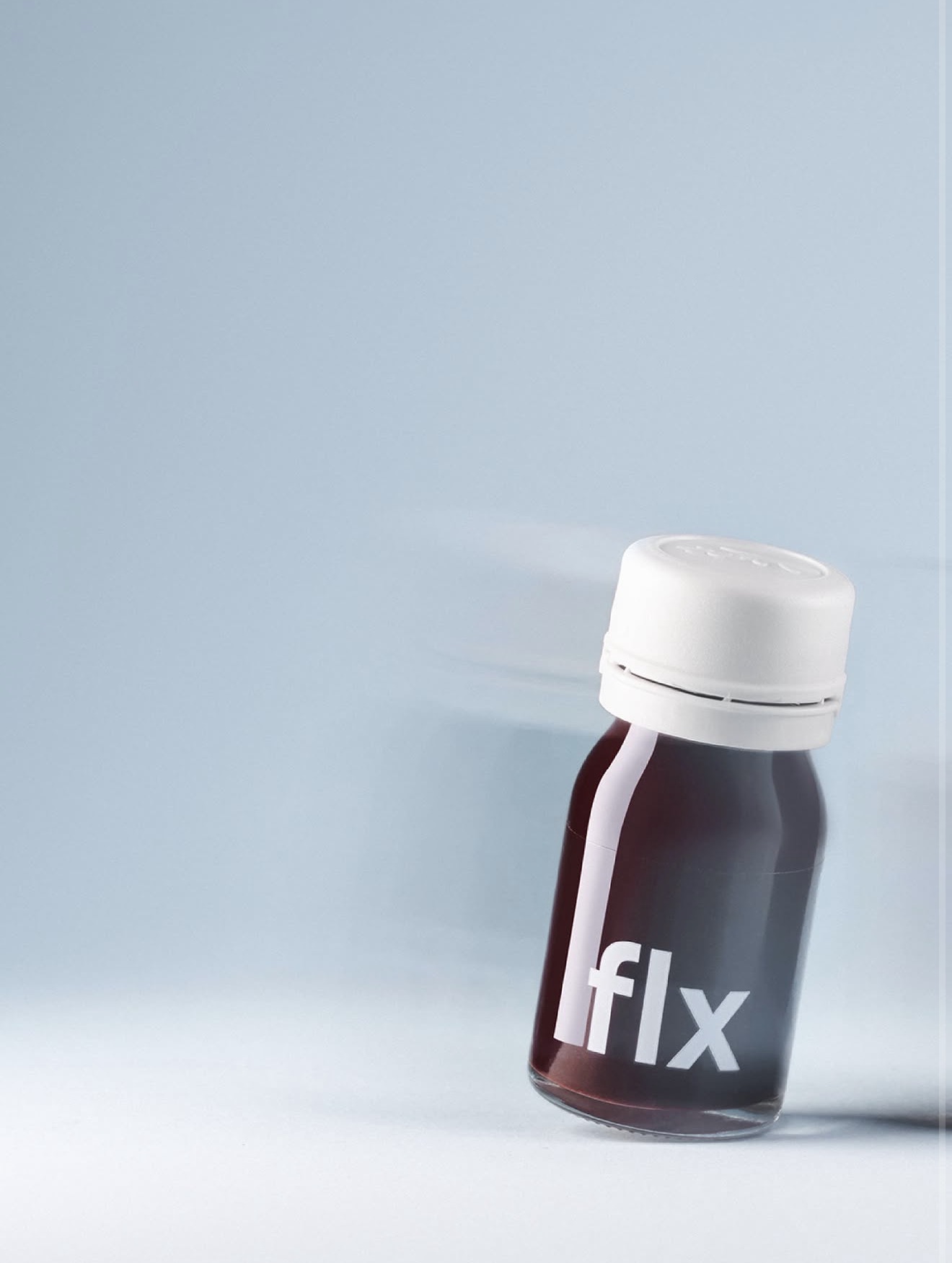 A small bottle against a pale blue background