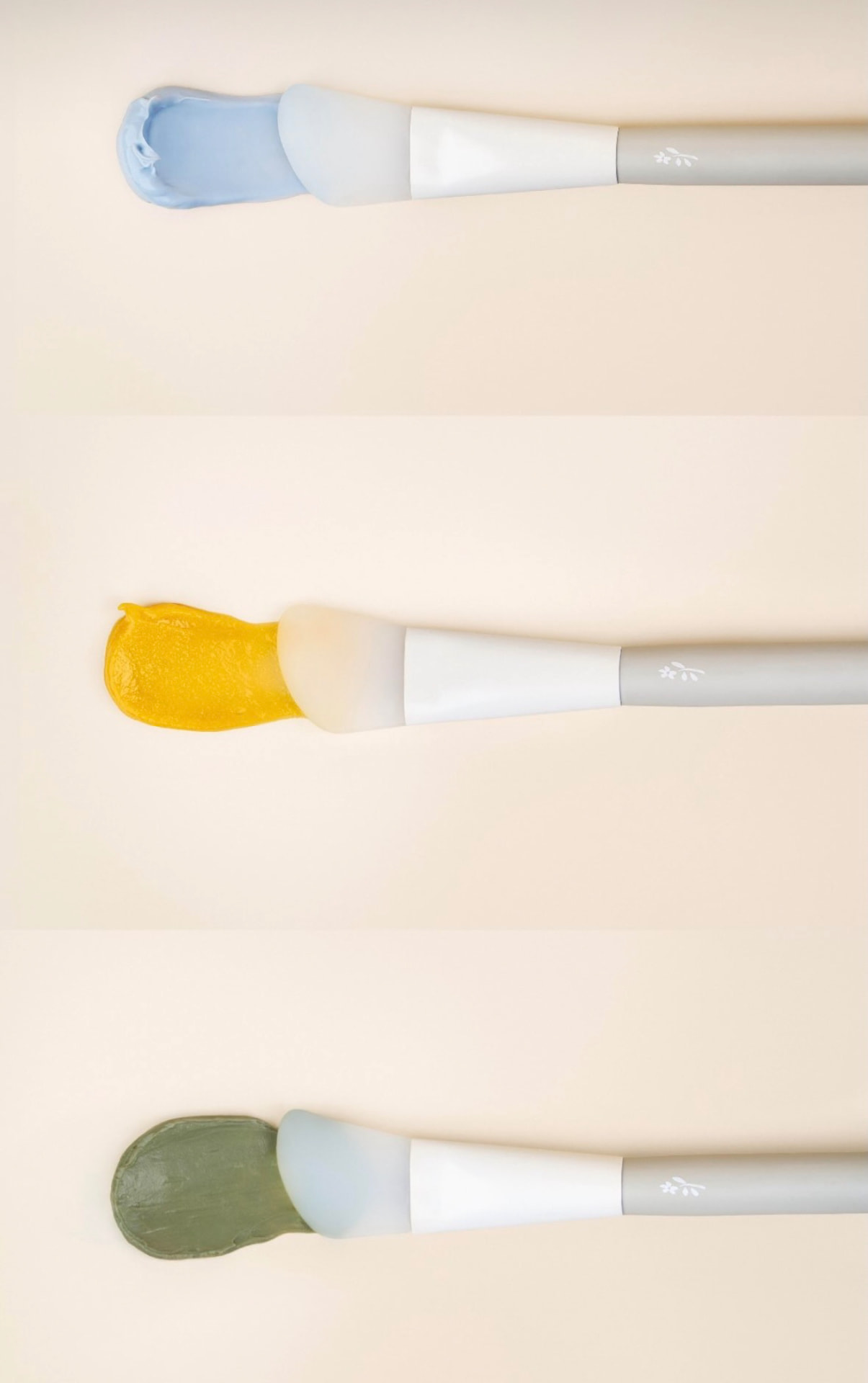 Three brushes with blue, yellow and green skincare
